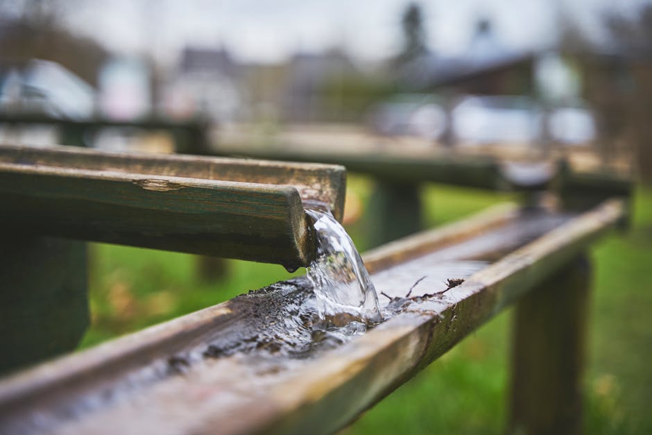 A detailed view of water flowing through a traditional bamboo irrigation setup.